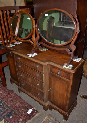 Lot 716 - A reproduction mahogany break front side cabinet and two toilet mirrors