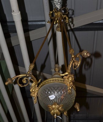 Lot 751 - A gilt metal and frosted cut glass pendant three branch light fitting cast with ram's masks