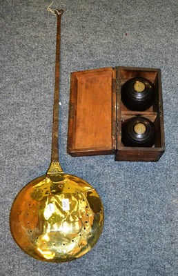 Lot 837 - An 18th century brass bed warming pan with iron handle and pair of Lignum Vitae lawn bowls in...