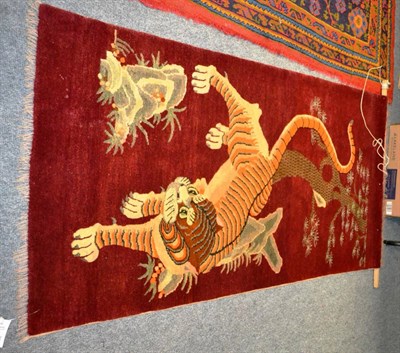 Lot 881 - Ningxia rug, China, the maroon field with a naturalistic tiger, 183 by 95cm