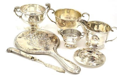 Lot 4 - A silver milk jug and sugar bowl, two silver twin-handled trophy cups, silver tongs, Scottish...