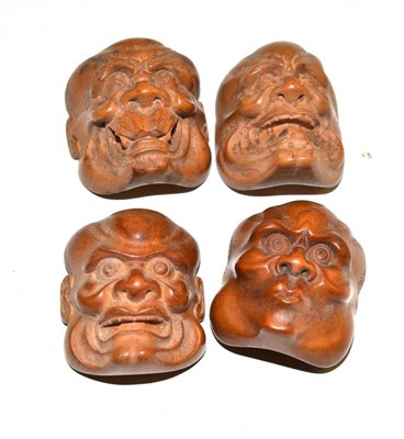 Lot 71 - A set of four Japanese carved wood 'Kabuki' masks in miniature