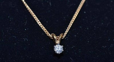 Lot 140 - A diamond solitaire pendant on a 9ct gold curb chain