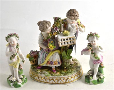 Lot 192 - A Dresden encrusted porcelain group with bird cage and a pair of Samson type porcelain putto...