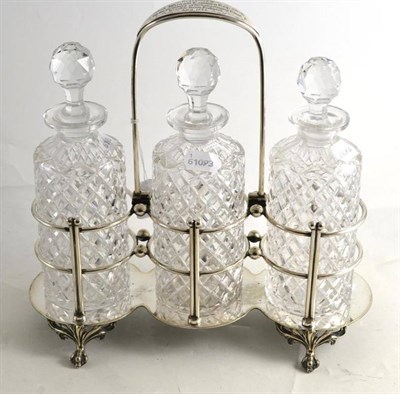 Lot 234 - A plated tantalus with three cut glass decanters and stoppers