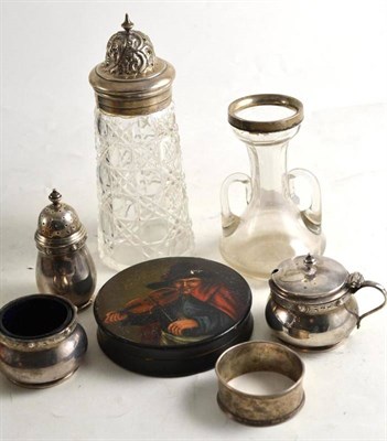 Lot 246 - Silver three piece condiment, silver napkin ring, silver topped sugar caster, silver rimmed jar and