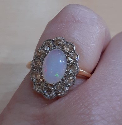 Lot 2127 - An Opal and Diamond Cluster Ring the oval opal...