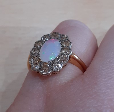 Lot 2127 - An Opal and Diamond Cluster Ring the oval opal...