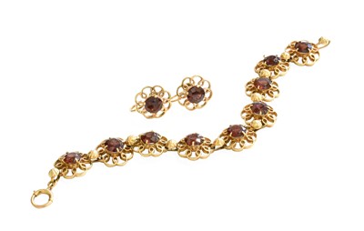 Lot 227 - A 9 Carat Gold Garnet Bracelet, nine round cut...