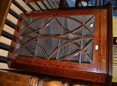 Lot 425 - A Georgian mahogany inlaid hanging corner cabinet with glazed doors