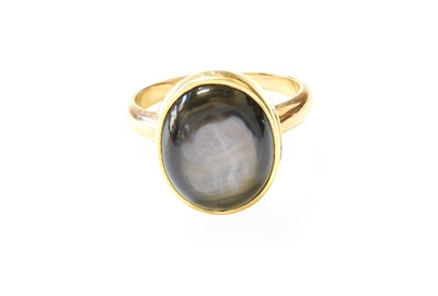 Lot 424 - A Cat's-Eye Stone Ring, the oval cabochon...