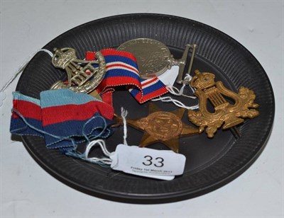 Lot 33 - Two medals, two cap badges and a black basalt teapot stand (5)