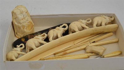 Lot 136 - Circa 1920s ivory and bone carvings including an elephant precession, papier mache spectacle...