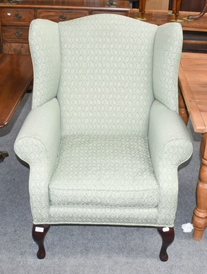 Lot 1204 - A 20th Century Wing Chair, in green foliate...