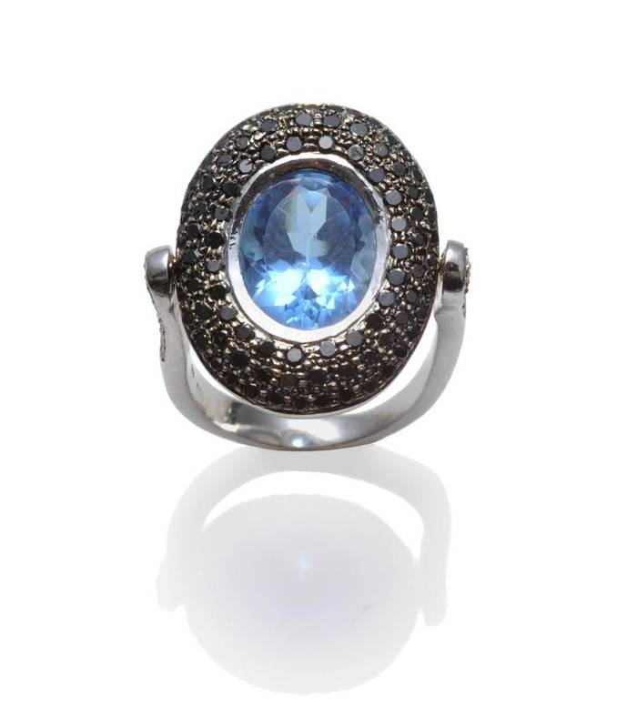 Lot 499 - An 18 Carat White Gold Blue Topaz, Black and White Diamond Flip Ring, the oval cut topaz in a white