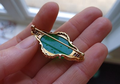 Lot 2067 - An Art Deco Jade and Diamond Brooch the oval...