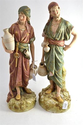 Lot 221 - A pair of Royal Dux porcelain figures of water carriers, early 20th century, the standing...