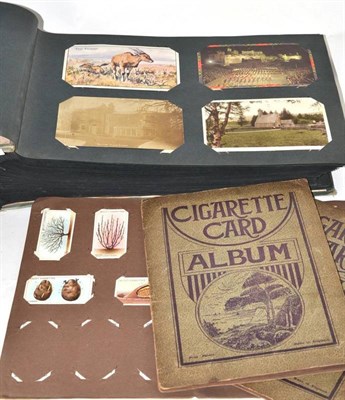 Lot 272 - An album of postcards and three albums of cigarette cards