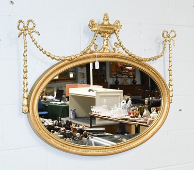 Lot 1172 - A Regency Style Oval Mirror, with urn and swag...