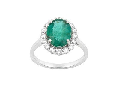 Lot 2208 - An Emerald and Diamond Cluster Ring the oval...