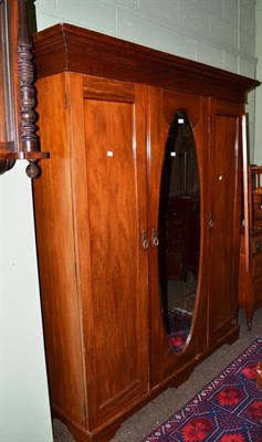 Lot 650 - A mahogany triple wardrobe with a mirrored door