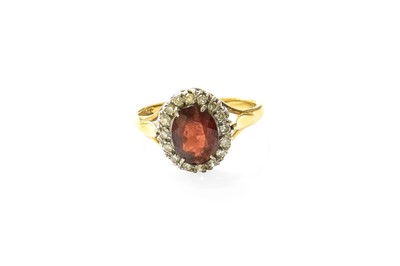 Lot 378 - A Garnet and Diamond Cluster Ring, the oval...