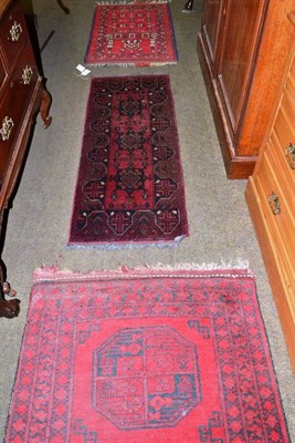 Lot 660 - Narrow Afghan runner, Afghan Turkestan, the blood red field with seven elephant foot guls...