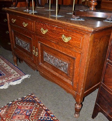 Lot 670 - A small carved oak sideboard