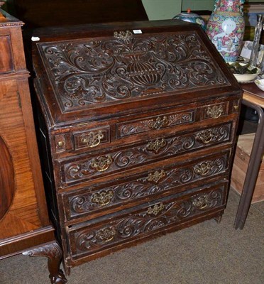 Lot 702 - An 18th century oak bureau with later carved foliate decoration