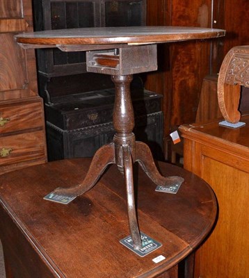 Lot 753 - An oak tripod table with bird cage action top