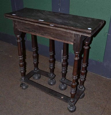 Lot 779 - A 17th century and later oak table with fold over top and fold out bobbin turned legs