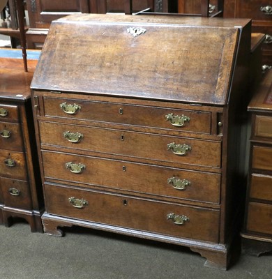 Lot 1310 - A George III Oak Bureau, fall flap opening to...