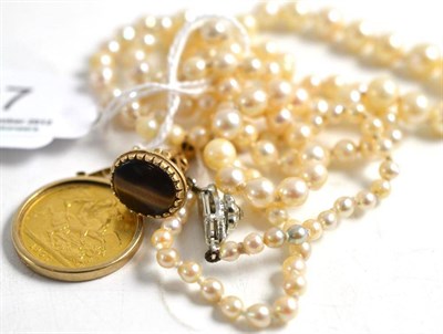 Lot 37 - A 1957 sovereign in a pendant mount, a 9ct gold seal fob and a strand of cultured pearls