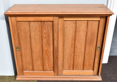 Lot 1432 - An Oak Bookcase with Panelled Sliding Doors,...