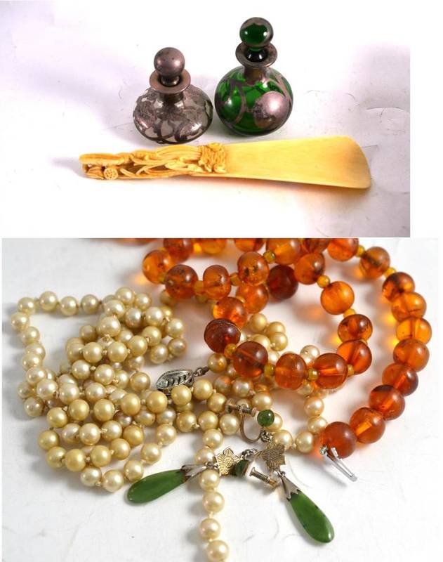 Lot 392 - A Japanese carved ivory shoe horn, two silver overlaid scent bottles, an amber type necklace,...