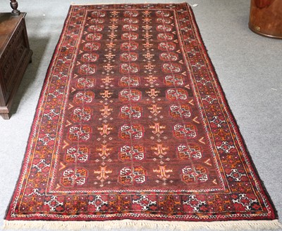 Lot 1087 - Baluch Rug, the chocolate field with three...