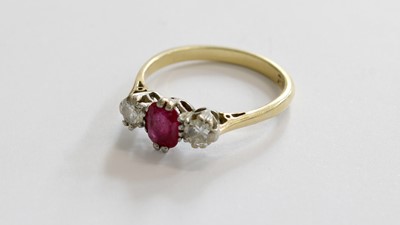 Lot 253 - A Ruby and Diamond Three Stone Ring, the oval...