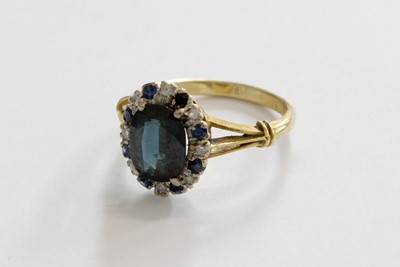 Lot 238 - A Sapphire and Diamond Cluster Ring, the oval...