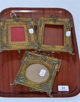 Lot 45 - Three gilt metal easel frames with painted decoration