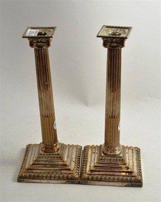 Lot 153 - A pair of plated on copper Corinthian column table candlesticks with associated sconces