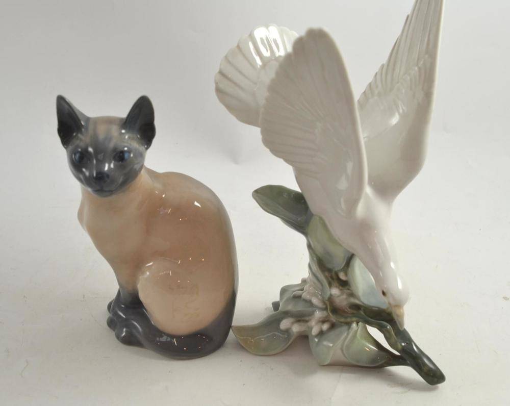 Lot 154 - A Royal Copenhagen figure of a Siamese cat and a Lladro figure of a dove on a branch (2)