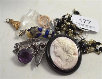 Lot 177 - A cameo brooch in a jet frame, a black and white bead necklace, a bunch of grapes motif pendant and