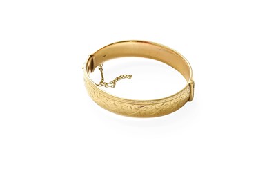 Lot 435 - A 9 Carat Gold Hinged Bangle, engraved to the...