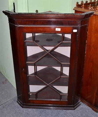 Lot 441 - A Georgian mahogany glazed hanging corner cabinet