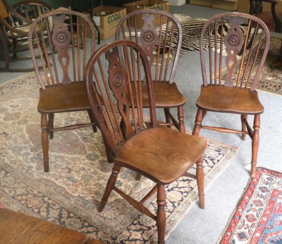 Lot 1258 - A Set of Four Elm Wheel Back Windsor Chairs