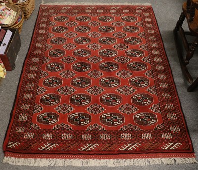 Lot 1150 - "Bukhara" Rug, The brick red field with four...