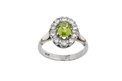 Lot 2303 - A Peridot and Diamond Cluster Ring the emerald-...