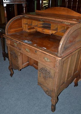 Lot 549 - A late Victorian/Edwardian small oak roll top desk on square section cabriole legs and key