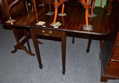 Lot 560 - A mahogany drop leaf table with reeded legs