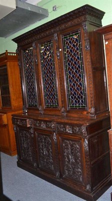 Lot 594 - A 19th century oak display cabinet, the upper section with leaded glazed panels over three...